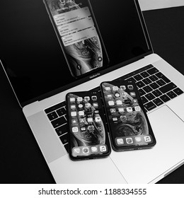 PARIS, FRANCE - SEP 25, 2018: New IPhone Xs And Xs Max Smartphones Model By Apple Computers Close Up Photo On The Keyboard Of Apple MacBook Pro Laptop 15 Inch - Wallpaper Liquid Black And White