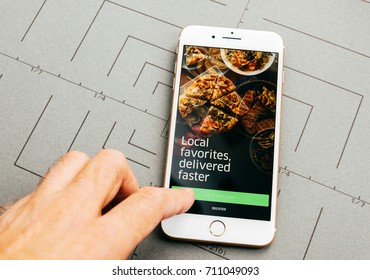 PARIS, FRANCE - SEP 26, 2016: Male Hand Holding New Apple IPhone 7 Plus After Unboxing And Testing By Installing The App Application Software Uber Eats Food Delivery App 