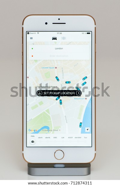 PARIS, FRANCE - SEP 26, 2016: New Apple iPhone 7 Plus in\
docking station after unboxing and testing by installing app\
application software set pickup location in London for Uber driver\
transportation 