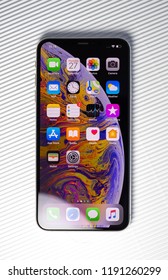 PARIS, FRANCE - SEP 27, 2018: new iPhone Xs Max smartphone model by Apple Computers close up with all home apps against stripes white background