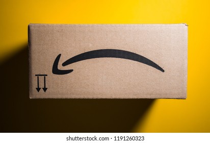 PARIS, FRANCE - SEP 28, 2018: Directly Above View Of New Amazon Cardboard Box Against Yellow Background. Amazon Prime Is The Online Paid Subscription Service Offered By Amazon.com Web-commerce Site -