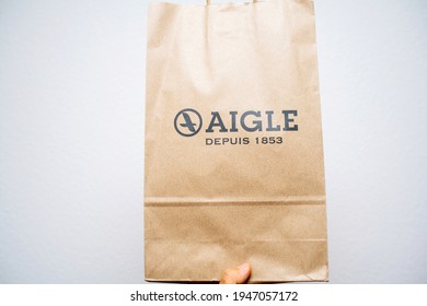 Paris, France - Sep 8, 2018: POV Male Hand Holding Paper Bag Package With Aigle Fashion Brand Printed