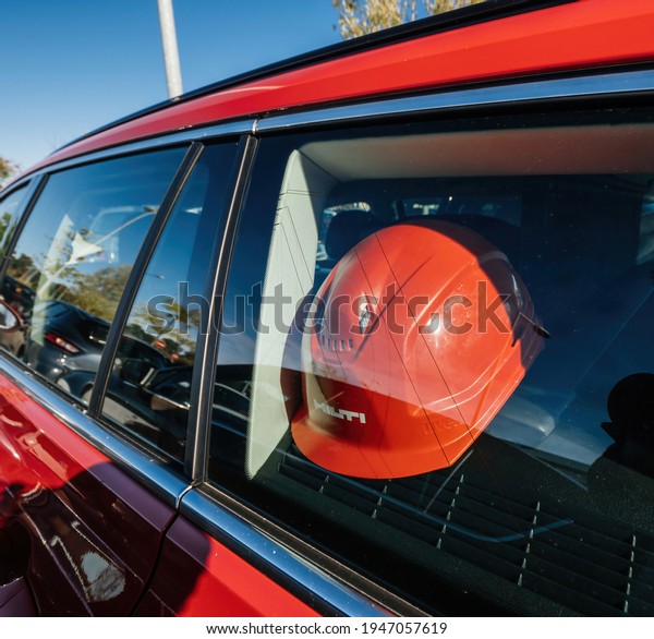Paris, France - Sep 8,\
2018: Hilti construction red hat in the park read car near the\
reconstruction site