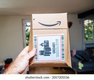 Paris, France - Sep 8, 2021: POV Male Hand Holding Package Of Amazon Prime Cardboard Package With UN3481 Stiker Norme Lithium Batteries Are Dangerous Goods And, As Such, Require Special Packaging