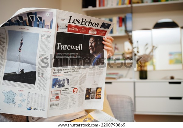 Paris, France - Sep 9, 2022: reading on living\
room couch latest Le Figaro newspaper cover page paying tribute to\
the Queen following her death - Queen Elizabeth II died at Balmoral\
Castle in Scotland