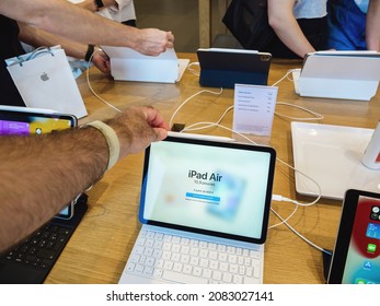 Paris, France - Sept 24, 2021: POV Male Hand Holding New Ipad Air In Apple Store With Multiple Hands Of Customers And Genius Workers In Background