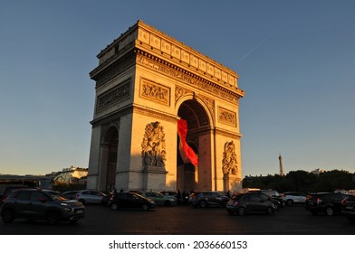 Paris, France - Sept. 25, 2018: The late-afternoon sun illuminates the landmark Arc de Triomphe as traffic flows around the monument in Place Charles de Gaulle in Paris.