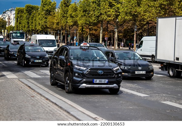 Paris, France - September 05, 2022 Taxi driving\
through the streets of Paris, This mode of transport is famous and\
widely used by Parisians and tourists, several companies compete in\
the city of Paris