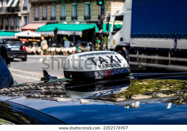 Paris, France - September 05, 2022 Taxi driving\
through the streets of Paris, This mode of transport is famous and\
widely used by Parisians and tourists, several companies compete in\
the city of Paris