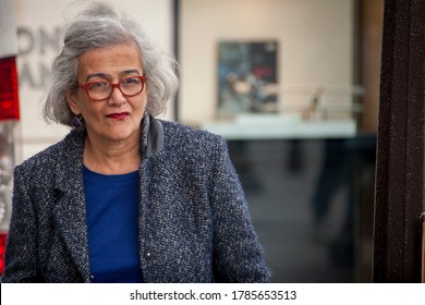 Paris / France - September 10, 2013: A Stylish Older Woman With Designer Glasses And Gray Hair Stands On A Paris Boulevard.