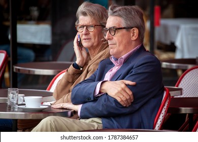 Paris / France - September 10, 2013: A Concerned Middle Age Couple Sit At A Sidewalk Cafe In Paris, France.