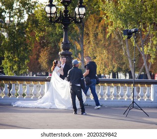 Paris, France - September 24, 2017: the work of a wedding photographer on the Alexander the Third Bridge with a view of the Eiffel Tower. Prestigious wedding in paris for foreigners from Asia
