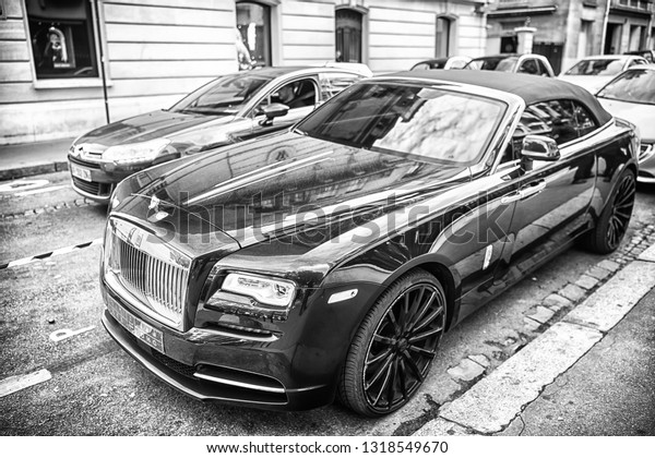 Paris, France - September 26, 23, 2017: luxury\
Supercar rolls royce rolls-royce ghost blue and gold color parked\
on the street in Paris. rolls royce rolls-royce is famous expensive\
automobile brand