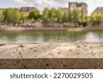 in Paris, France, shallow focus on a stone ledge on a bridge overlooking the Seine River.