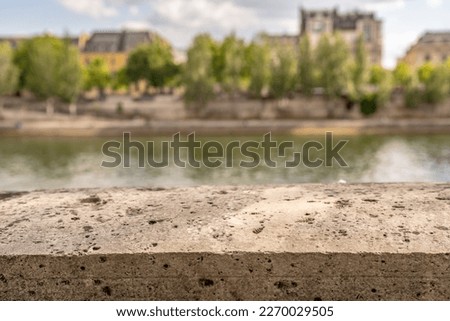 in Paris, France, shallow focus on a stone ledge on a bridge overlooking the Seine River.