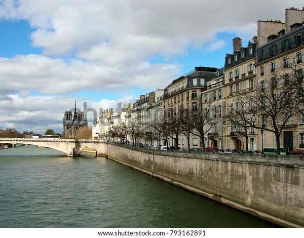 Paris, France, spring. On the right\
is the Quay de Bethune on the island of Saint-Louis. Ahead of the\
Pont de La Tournelle and the Notre-Dame de\
Paris