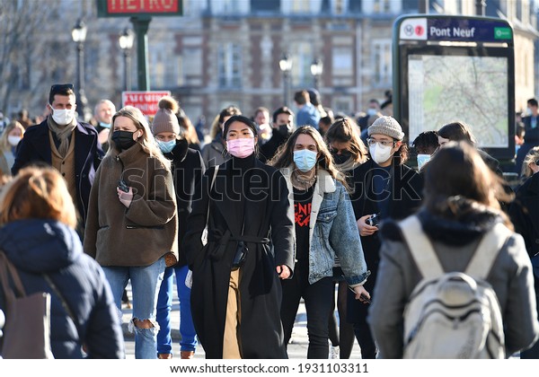 Paris, France-03 02 2021:People wearing\
protective face masks in a crowded street of Paris, France, during\
the global coronavirus\
epidemic.