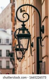 Paris, France.Typical and vintage metal street lamp suspended on the building. Lantern hanging from the house wall. 