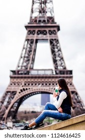 Paris. The girl in Paris. Eiffel Tower. photo with a view of the tower. concepts of coffee with you in Paris. tourist travel girl in jeans pants with long dark hair. background without face