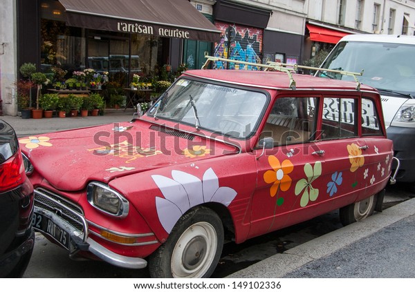 PARIS - MARCH 17: Red car painted with flowers on\
the street near florist shop as seen on March 17, 2013 in Paris,\
France. Such creative solutions are original contribution to urban\
culture of Paris.