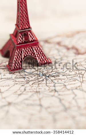 Paris name at a map with red Eiffel tower miniature (blurred copy space)/Travel Destination Paris