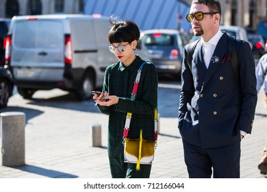 PARIS - OCTOBER 5, 2016: Stylish Asian Woman And European Man Walking At Vendome Square During Paris Fashion Week After Louis Vuitton Show Spring/summer 2017. Street Style