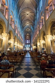 PARIS - SEPT 25, 2013: People Visit The Notre Dame De Paris. Cathedral Of Notre Dame Is One Of The Top Tourist Destinations In France. Interior Of The Famous Gothic Notre Dame.