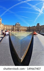 PARIS - SEPT 8: The World-famous Entrance To The Louvre - Fountain September 8, 2012 In Paris. Tourists Resting On A Granite Fence Fountain. Picture Taken Fisheye Lens