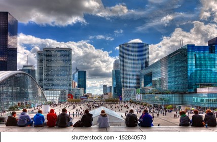 PARIS,APRIL 15: Teenagers siting on the steps and admiring the modern architecture in La Defense,in western of Paris,France on April 15 2012. Here are many of the Paris urban area's tallest high-rises