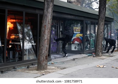 Paris,France May 1,2018.Masked Youth Protesters Attack A Shop Front While Clashing With French Police Force During A March For The Annual May Day Workers' Rally.