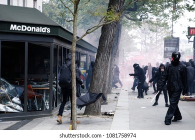 Paris,France May 1,2018.Masked Youth Protesters Attack A Shop Front While Clashing With French Police Force During A March For The Annual May Day Workers' Rally.