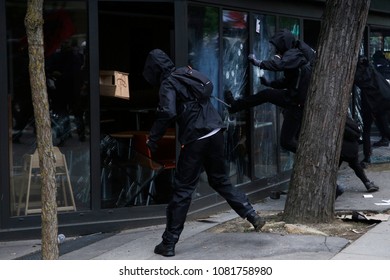 Paris,France May 1,2018.Masked Youth Protesters Attack A Shop Front While Clashing With French Police Force During A March For The Annual May Day Workers' Rally.