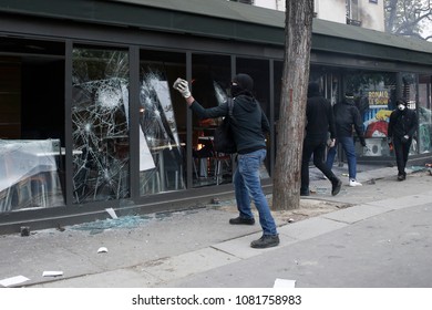 Paris,France May 1,2018.Masked Youth Protesters Attack A Shop Front While Clashing With French Police Force During A March For The Annual May Day Workers' Rally.