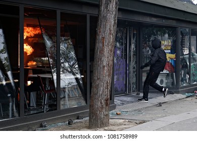 Paris,France May 1,2018.Masked Youth Protesters Attack A Shop Front While Clashing With French Police Force During A March For The Annual May Day Workers' Rally.