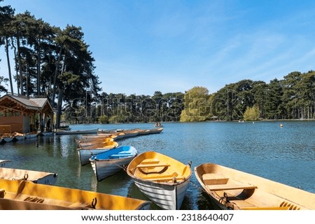 Parisians boating on the lower lake in the Bois de Boulogne on a sunny day of April.