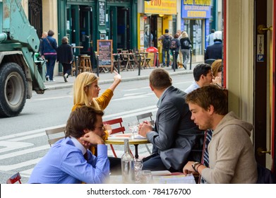 Parisians and tourists enjoy food and drinks in cafe sidewalk in Paris, France, Paris, October 02, 2014. Paris is one of the most populated metropolitan areas in Europe - Shutterstock ID 784176700