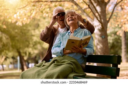 Park, bench and binoculars with a senior couple birdwatching together outdoor in nature during summer. Spring, love and book with a mature man and woman bonding while sitting in a garden for the view - Shutterstock ID 2233468469