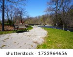 Park bench sits empty alongside a walking path at Settlers Park in Sheboygan Falls, Wisconsin 