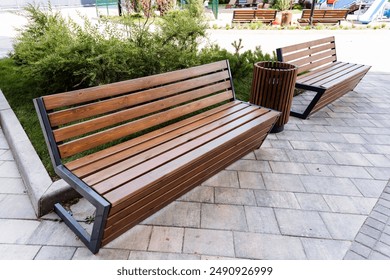 The park boasts of two wooden benches, a trash can, outdoor furniture, and lush green grass, making it a charming outdoor area for visitors to relax and appreciate nature - Powered by Shutterstock