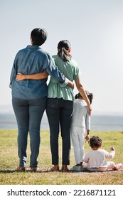 Park, Nature And Back View Of Family On Grass Outdoors With Relatives Spending Quality Time Together. Love, Support And Caring Grandma, Mom And Girl With Baby Bonding Together With Scenic Ocean View.