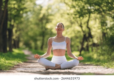 Park pathway, doing exercise. Beautiful fitness yoga woman is outdoors, amazing nature.