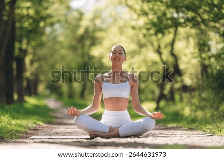 Park pathway, doing exercise. Beautiful fitness yoga woman is outdoors, amazing nature.