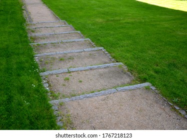 Park Stairs Made Of Beige Gravel Material Bordered By Granite Cubes Follow The Gravel Path With A Longitudinal Groove Of Granite Stone Cubes Around The Lawn Gutter Channel