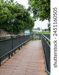 Park Street corridor wooden step bridge with black railings and a white bridge in the distance with a small river next to it