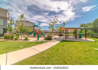 Park at a sunny neighborhood with childrens playground and pavilion eating area