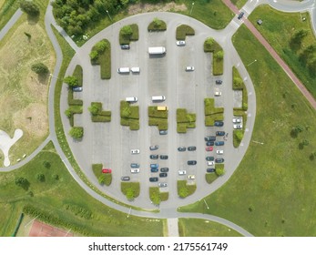 Park top down urban style parking symmetrical landscape. Road infrastructure and green plants nature overhead top down aerial drone view. Vehicle parking lot.