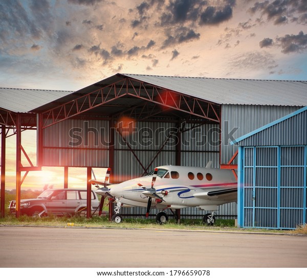 parked airplane at\
the hangar in the\
airfield