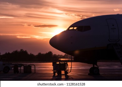 Parked Airplane Side View Backlit, Sunset Time.