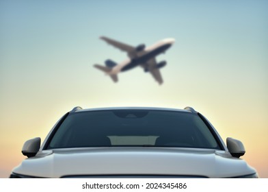 Parked Car in airport with taking off airplane on sky background. Transfer concept.