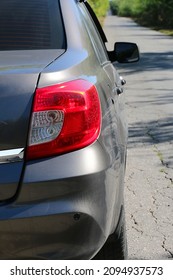 A Parked Car On A Road Leading Away Into The Distance. The Back Of The Car Is A Plafond Of Lighting